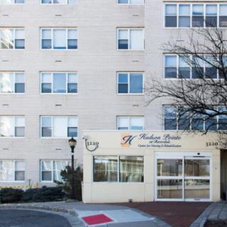 An exterior view of a multi-story apartment building with several windows and an entrance labeled as 'Rescue From The Heart Inc.'.