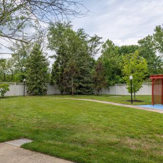 A well-maintained backyard with lush green grass and surrounding trees.