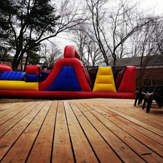 A vibrant inflatable bounce house set up on a wooden deck, perfect for outdoor fun.