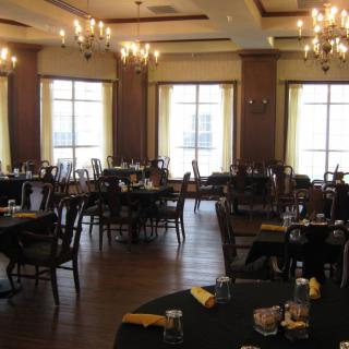 An elegant dining room with chandeliers and neatly arranged tables and chairs.
