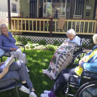 A group of seniors enjoying a sunny afternoon together in a garden.