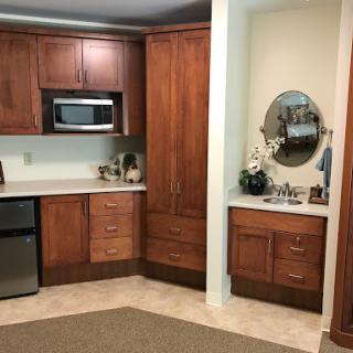 A cozy kitchen featuring wooden cabinets, a countertop, and a microwave.