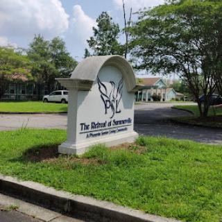 Entrance sign for The Batik & Textiles, set in a green landscape.