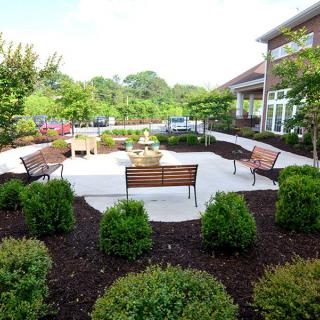 A beautifully landscaped garden with benches and a patio area.