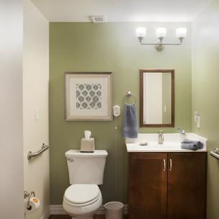 Modern bathroom with a green accent wall and simple decor.