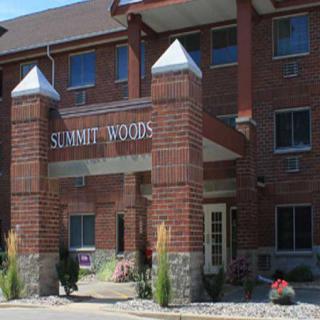 The entrance to Summit Woods featuring brick architecture and landscaped details.