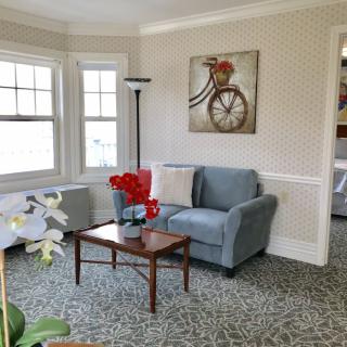Cozy living room with a blue armchair, coffee table, and wall art featuring a bicycle.