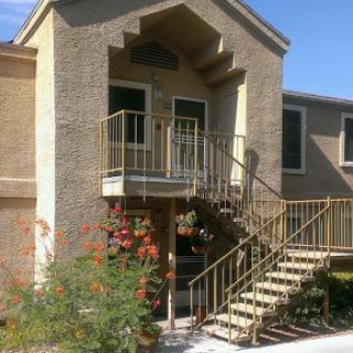 A view of the entrance to a multi-story residential building with an outdoor staircase.