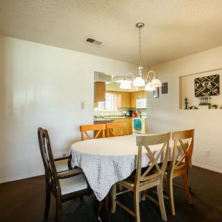 A cozy dining area with a round table and mixed chairs, adjacent to a kitchen.