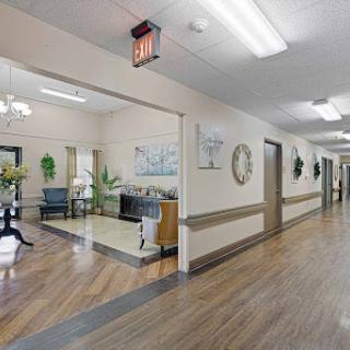 A well-lit hallway in a care facility, featuring decorative elements and comfortable seating.