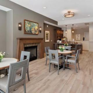 A modern dining area with a fireplace, wood flooring, and stylish furnishings.