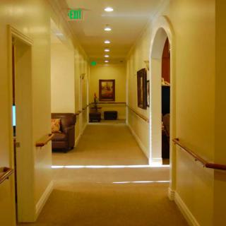 A well-lit hallway with carpeted flooring and an archway.