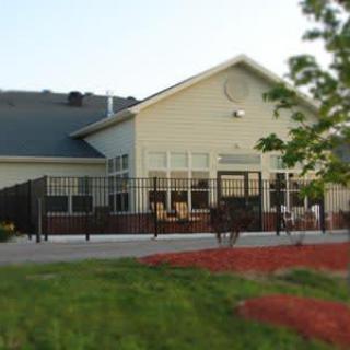 A view of a building with a patio and landscaped garden.