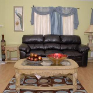 A cozy living room with a leather sofa, ornate coffee table, and elegant decor.