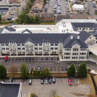 Aerial view of a multi-story building with a parking lot in a residential area.