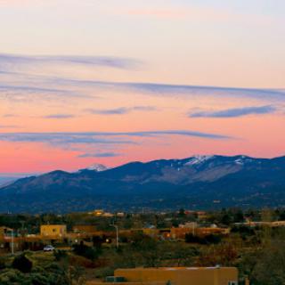 A serene sunset over the mountains, casting a colorful glow in the sky.
