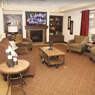 A cozy living room with a fireplace and television, featuring comfortable seating and warm decor.