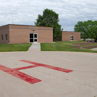 A view of a medical facility featuring a helipad in the foreground.