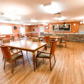 A spacious and inviting dining area featuring wooden furniture and warm tones, ideal for gatherings.