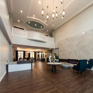 A modern and spacious lobby with elegant chandeliers and comfortable seating.