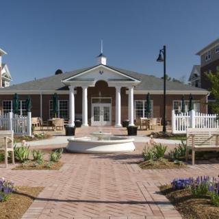 A well-maintained building with classical columns and landscaped surroundings on a sunny day.