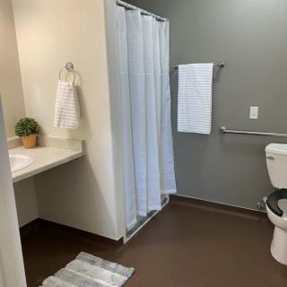 A modern, clean bathroom with a shower, toilet, and sink.