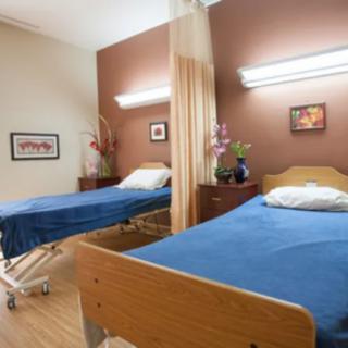 A hospital room featuring two patient beds separated by a curtain.