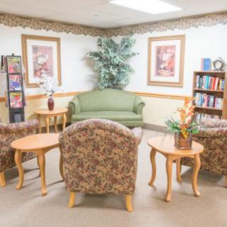 A cozy waiting room with comfortable seating and a bookshelf for relaxation.