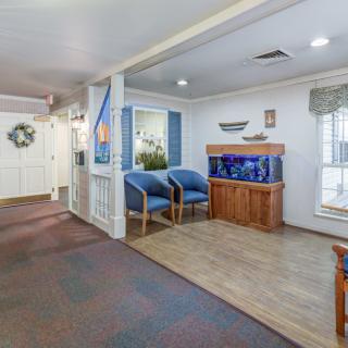 A cozy lobby area with an aquarium, seating, and natural light from windows.