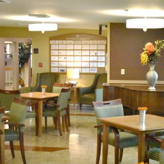 A cozy lounge area featuring tables and chairs, ambient lighting, and a decorative vase with flowers.