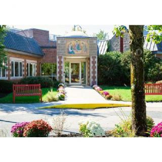 A picturesque building entrance with a landscaped path and colorful flowers.