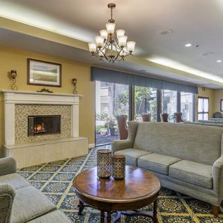 A cozy living room with comfortable sofas, a fireplace, and a chandelier illuminating the space.