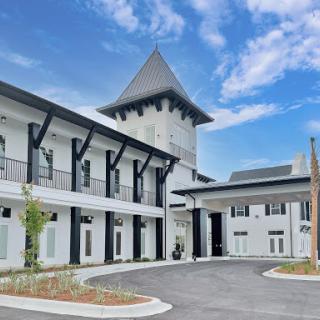 A beautifully designed modern building featuring a unique tower and a spacious courtyard.
