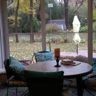 A cozy indoor dining area overlooking a backyard with autumn leaves.