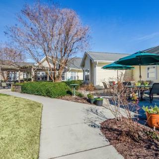 A well-maintained residential garden with a patio and pathway on a sunny day.
