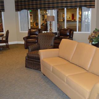 A modern living room with a beige sofa and brown armchairs.