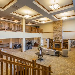 A spacious and elegantly decorated lobby with a fireplace, comfortable seating, and warm lighting.