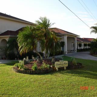 A well-maintained house with a palm tree and vibrant landscaping in the front yard.