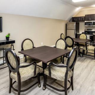 Modern kitchen with dining area featuring a dark wooden table and upholstered chairs.
