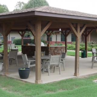 A spacious outdoor pavilion featuring wooden pillars and seating, ideal for gatherings.