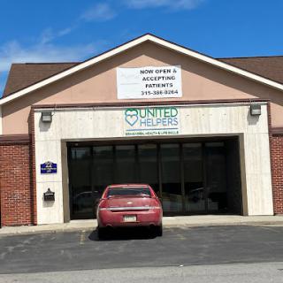 Exterior view of a United healthcare clinic with a red car parked in front.