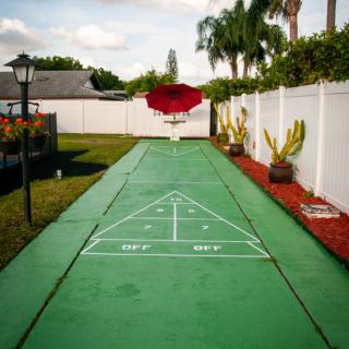 Outdoor shuffleboard court in a backyard setting.