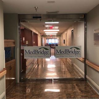A hospital corridor with MedBridge signage on the entrance doors.