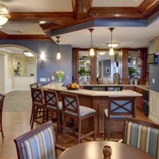 A stylish kitchen with a bar area, featuring pendant lights and wooden accents.