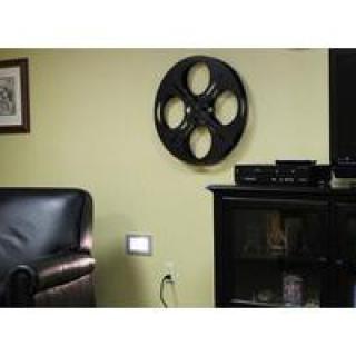 A living room decorated with a movie reel wall art above a cabinet.