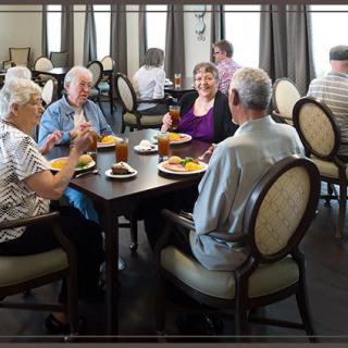 A group of seniors enjoying a meal together at a community dining area.