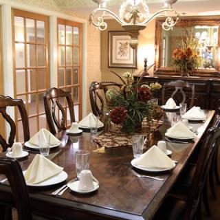 A beautifully set formal dining table with elegant decorations and a central floral arrangement.