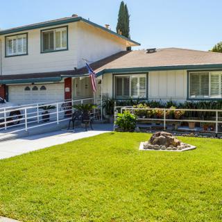 A suburban house with a well-maintained lawn and driveway.