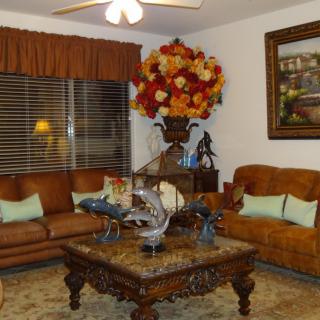 A cozy living room with leather sofas, a wooden coffee table, and elegant decor.