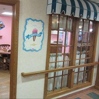 Interior view of an ice cream shop with a window and striped awning.